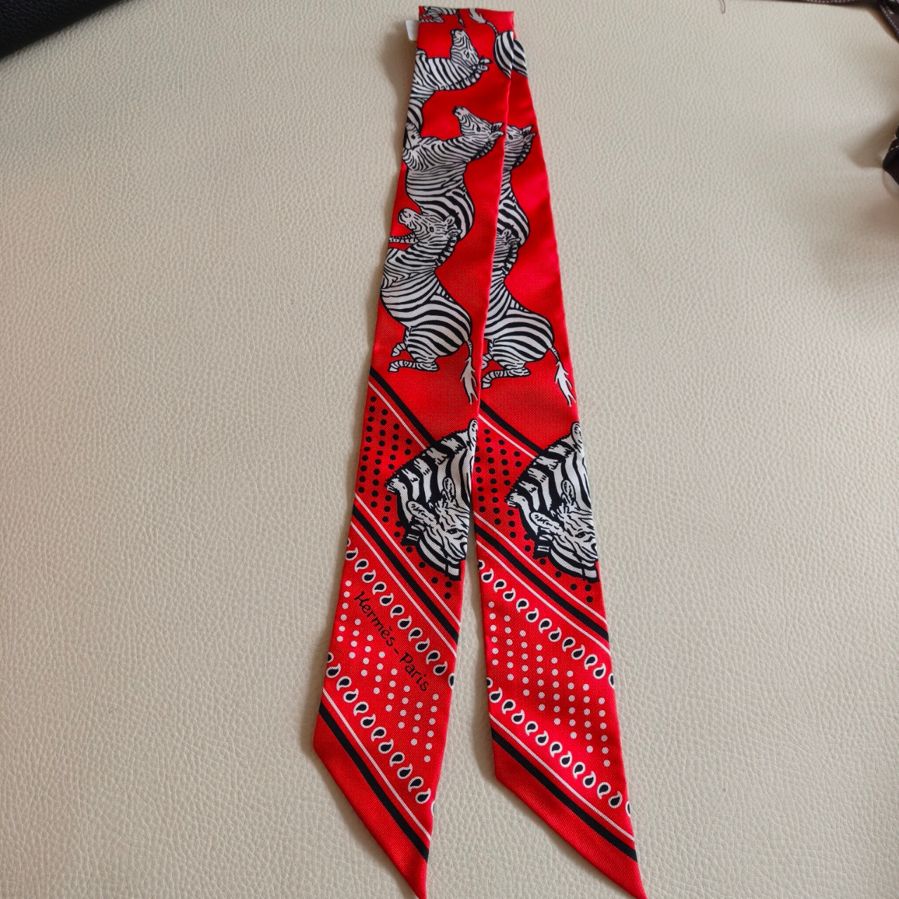 Pre-owned Certified Hermes Silk Twilly “Less Zebres” in Red and White, w/box